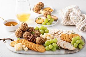 Cheese balls or truffles on a cheese board with crackers photo