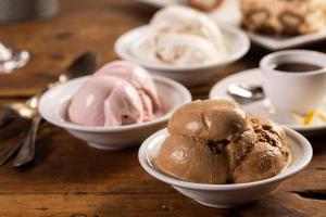 Variety of italian gelato served in bowls on a wooden table photo