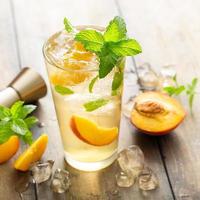 Summer peach mojito cocktail with fresh mint, lime and peach slices