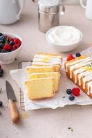 Classic vanilla pound cake with powdered sugar glaze sliced on parchment photo