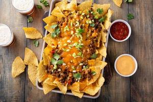 Traditional nachos with ground beef and red pepper photo