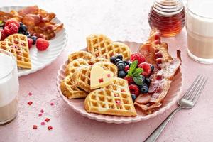 Valentines day breakfast with heart shaped waffles, bacon and berries photo