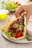 Chicken souvlaki with fresh vegetables on a flatbread photo