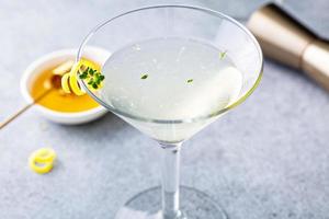 Honey and thyme lemon drop martini with garnish photo