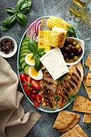 Grilled chicken platter with vegetables, eggs, feta cheese photo