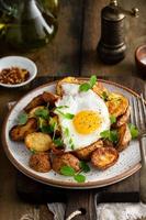 Rustic roasted potatoes with fried egg for breakfast