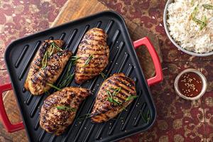 Grilled teriyaki chicken breast on a grill pan with green onions photo