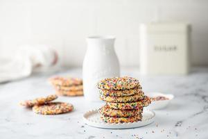 Sugar cookies with sprinkles and a bottle of milk photo