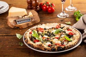 Freshly baked vegetarian Neapolitan pizza with mushrooms and artichokes photo