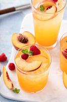 Refreshing summer cocktail with peach and raspberry photo
