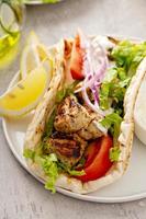 Chicken souvlaki with fresh vegetables on a flatbread photo