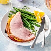Easter baked ham served on a plate with green beans photo