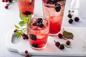 refrescante cóctel de moras con una ramita fresca de romero foto