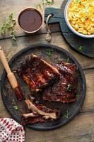 Grilled barbeque ribs with BBQ sauce and sides photo