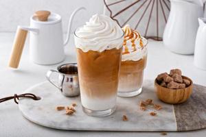 Iced caramel latte topped with whipped cream and caramel sauce photo