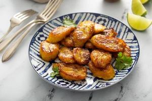 Fried caramelized plantains served with lime wedges photo