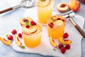 Refreshing summer cocktail with peach and raspberry photo