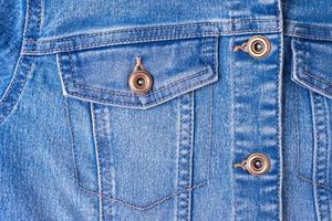 Denim jeans texture backgrouns. Pocket and buttons of jeans jacket close up photo