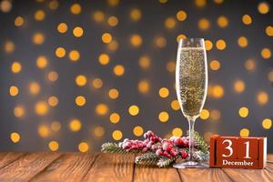 Wine glass with bubbly Champagne on blurry sparkling lights background photo