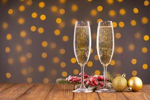 Two wine glasses with bubbly Champagne on blurry sparkling lights background photo