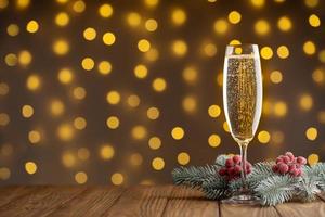 Wine glass with bubbly Champagne on blurry sparkling lights background photo