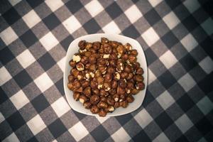 Handful of nuts on bowl plate photo