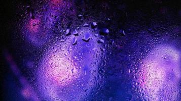 Purple Neon Blurred Lights Through Glass Window With Raindrops On It in Karachi Pakistan 2022 photo