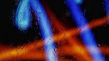 Purple Neon Blurred Lights Through Glass Window With Raindrops On It in Karachi Pakistan 2022 photo