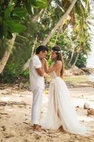 Young and beautiful couple is celebrating wedding on the beach photo