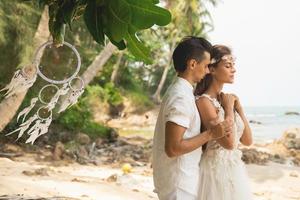 Young and beautiful couple is celebrating wedding on the beach photo