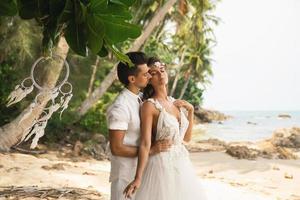 Young and beautiful couple is celebrating wedding on the beach photo