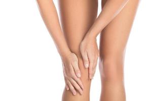 Woman with pain in her knee against white background photo