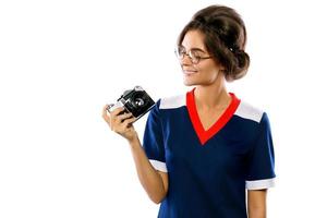 Woman model in vintage look holding retro camera in her hands photo