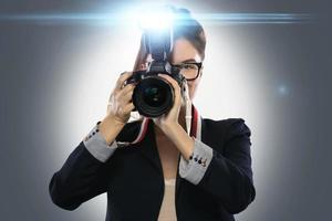 Woman photographer with DSLR camera using flash photo