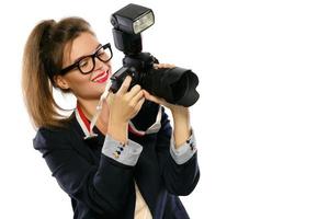 mujer fotógrafa con una cámara réflex digital sobre fondo blanco foto