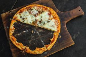 Delicious baked pizza with crunchy crust on wooden board photo