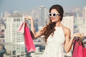 Beautiful woman with a shopping bags in the big and modern city photo