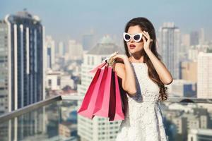 Beautiful woman with a shopping bags in the big and modern city photo