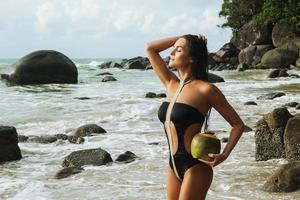 mujer vestida con traje de baño y relajándose en la playa tropical foto