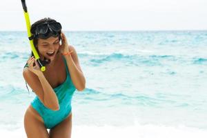 Happy woman on the beach with mask for snorkeling photo