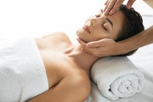 Young and beautiful woman during facial massage session photo