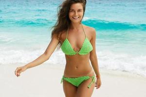 Woman in green crochet bikini on the beach. Beach holidays beside the sea. photo