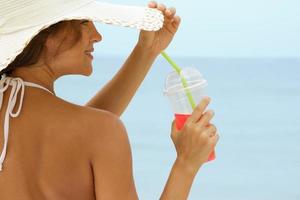 Woman in beach hat with a cocktail photo