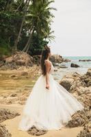 Bride wearing beautiful wedding dress on the tropical beach photo