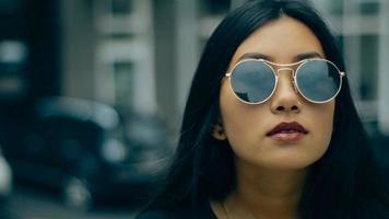 schoonheid brunette Aziatisch meisje met Purper lippen poseren in de straat in de stad video