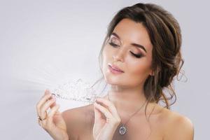 Portrait of young beautiful bride holding diadem photo