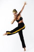 Stylish woman with yellow hair and trackpants on gray background photo