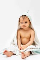 Cute baby wrapped into hooded towel after a bathing photo