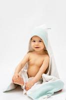 Cute baby wrapped into hooded towel after a bathing photo