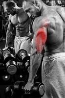 Triceps specialization in bodybuilding. Man during workout in the gym photo